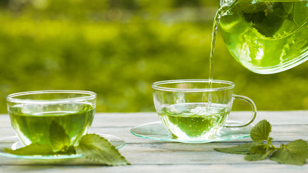 Tazas de infusión de melisa con hojas frescas, un remedio natural para calmar los nervios y favorecer el descanso nocturno.